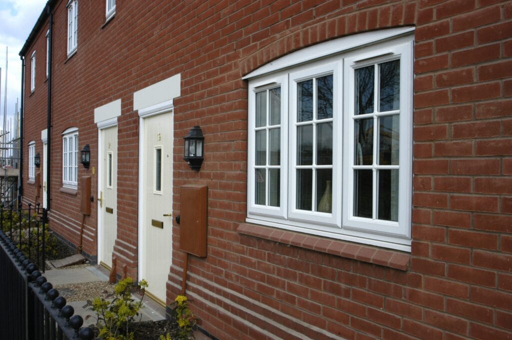 white window frame and doors on a red brick house.