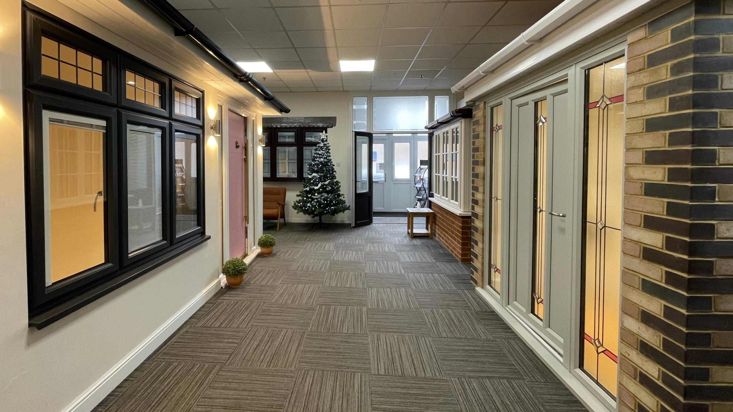 Inside Park Lane Windows showroom displaying a range of window and door styles, including black casement windows and a decorative glazed door