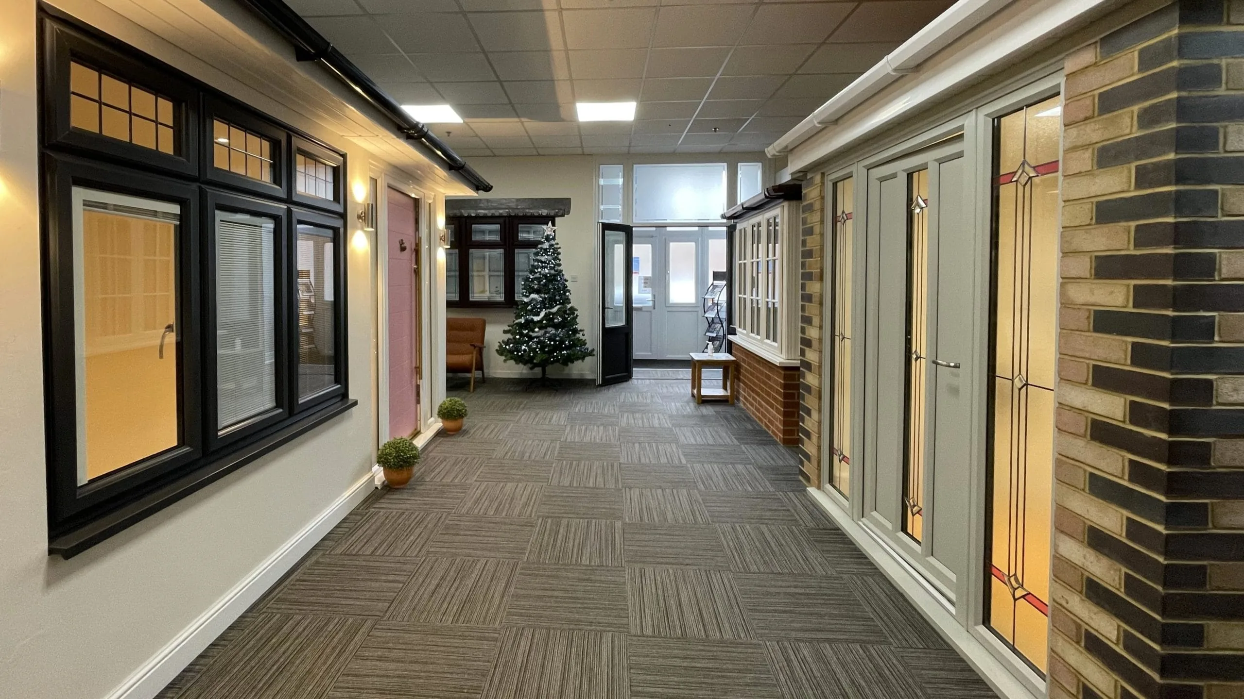 Inside Park Lane Windows showroom displaying a range of window and door styles, including black casement windows and a decorative glazed door