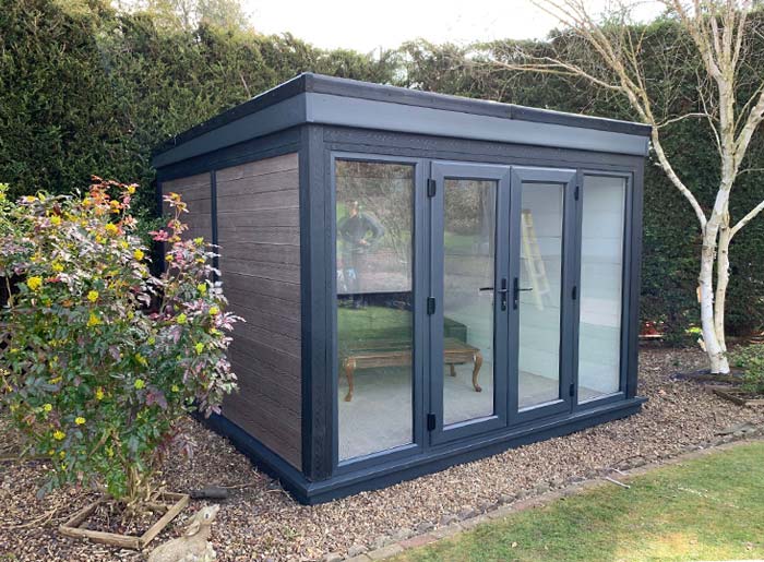 Ashmere garden room with dark composite cladding and anthracite grey French doors, installed in a residential garden.